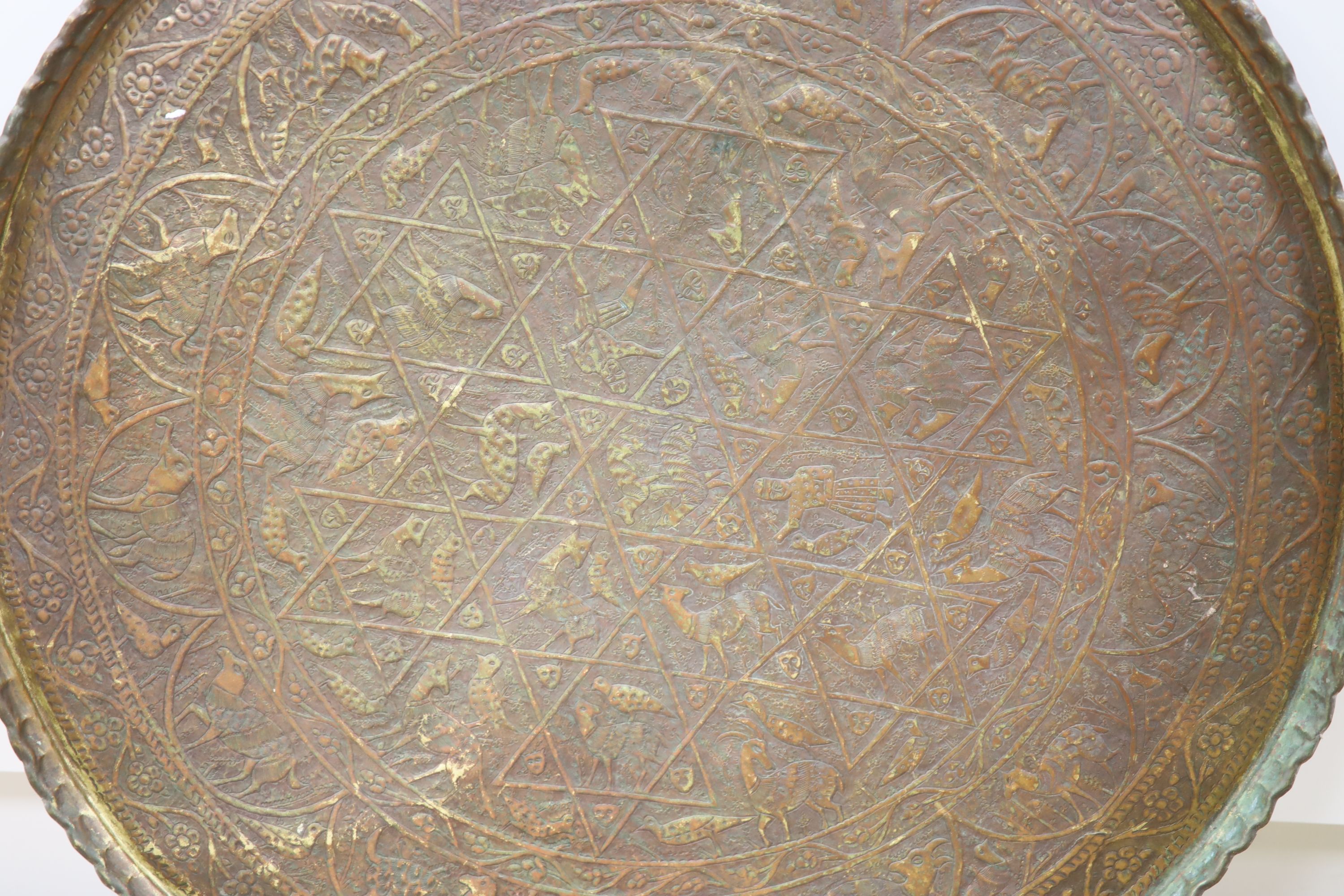 A large Persian engraved brass tray, 86cm diameter